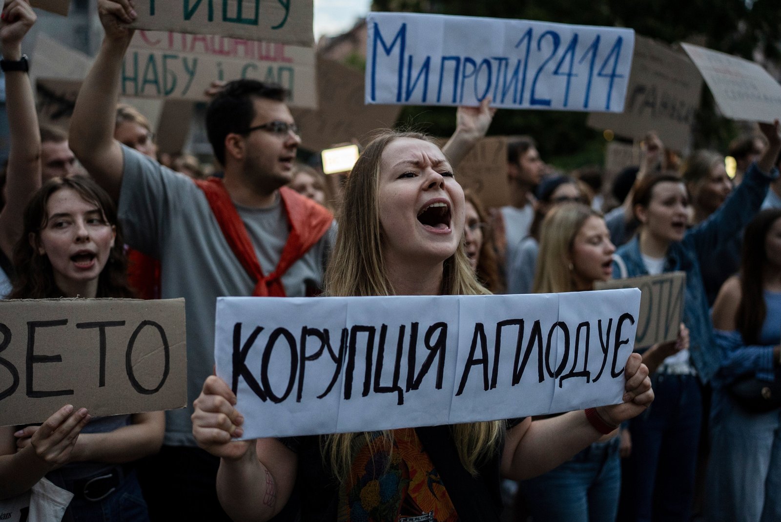 A woman chants while holding a banner that reads, “Corruption Applauds,” during a protest against a law targeting anti-corruption institutions in central Kyiv, Ukraine, on July 22, 2025.