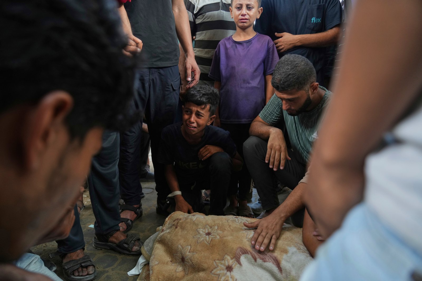 Abdul Karim Foura, center, mourns over the body of his uncle, Mohammed Foura, who was killed in an Israeli airstrike in Gaza Strip, outside the morgue of the Shifa Hospital, in Gaza City, Saturday, July 26, 2025. (AP Photo/Abdel Kareem Hana)
