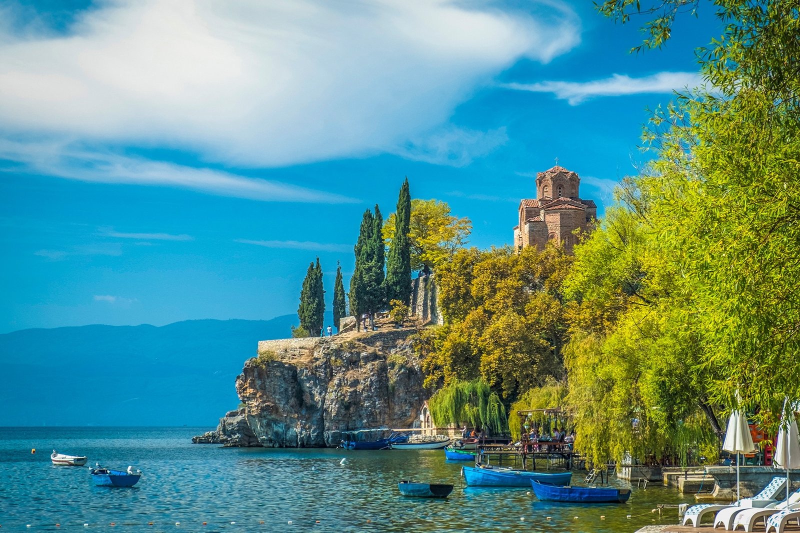 A castle looks over the lake from a craggy clifftop