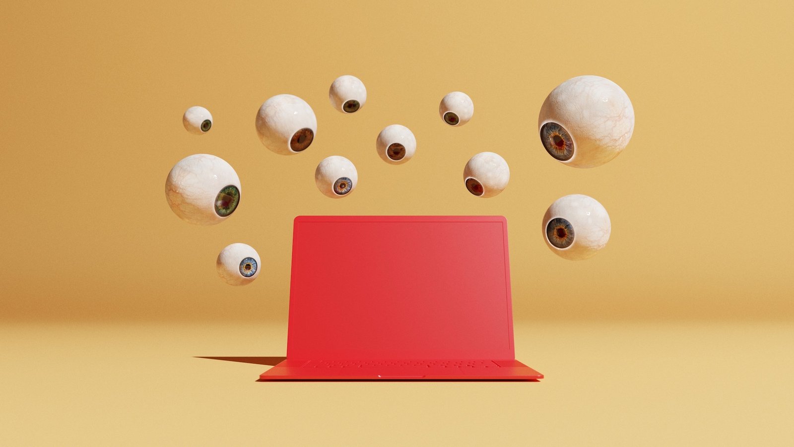 Conceptual image with a bunch of floating eyeballs in different sizes overlooking a red computer, could symbolize ideas around malware and computer viruses