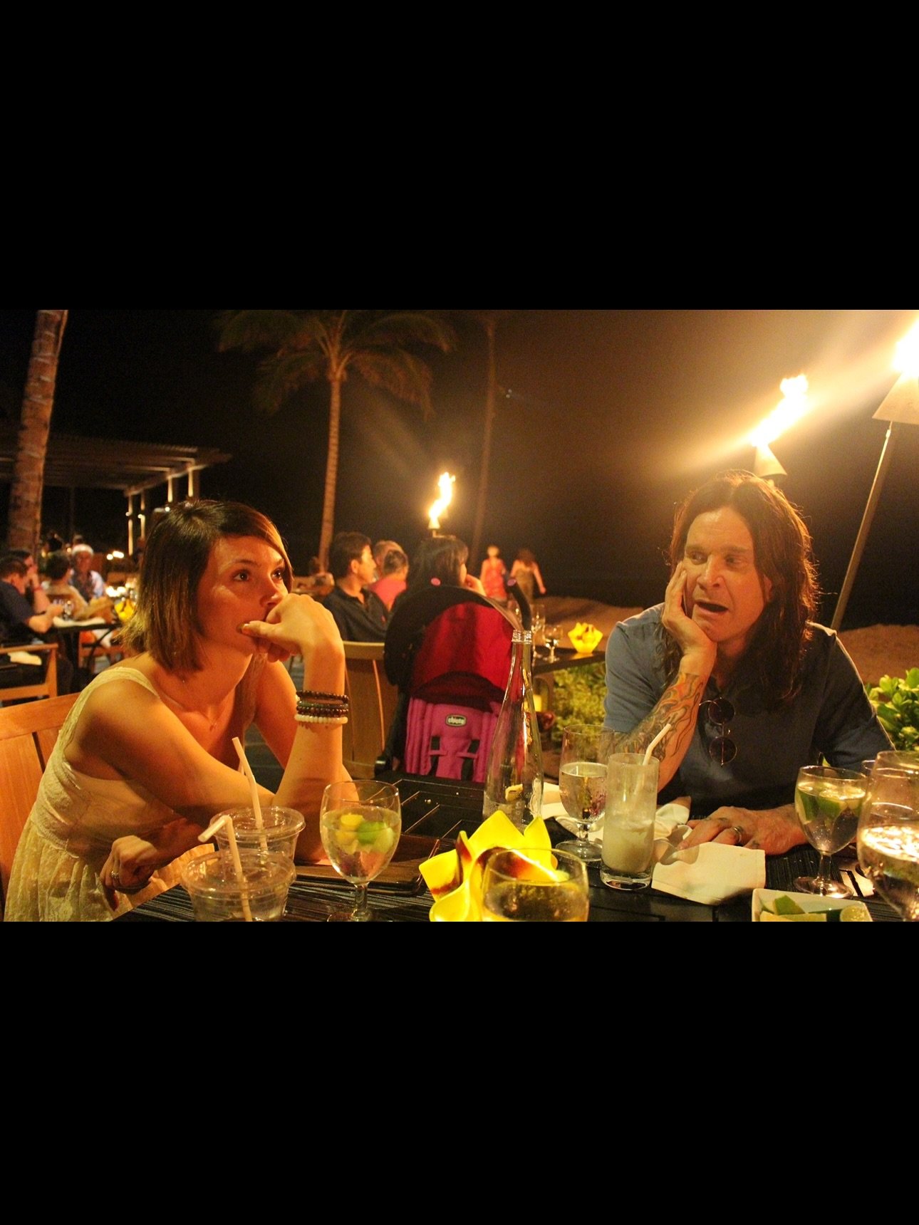 Lisa Stelly with Ozzy Osbourne at an outdoor table. 
