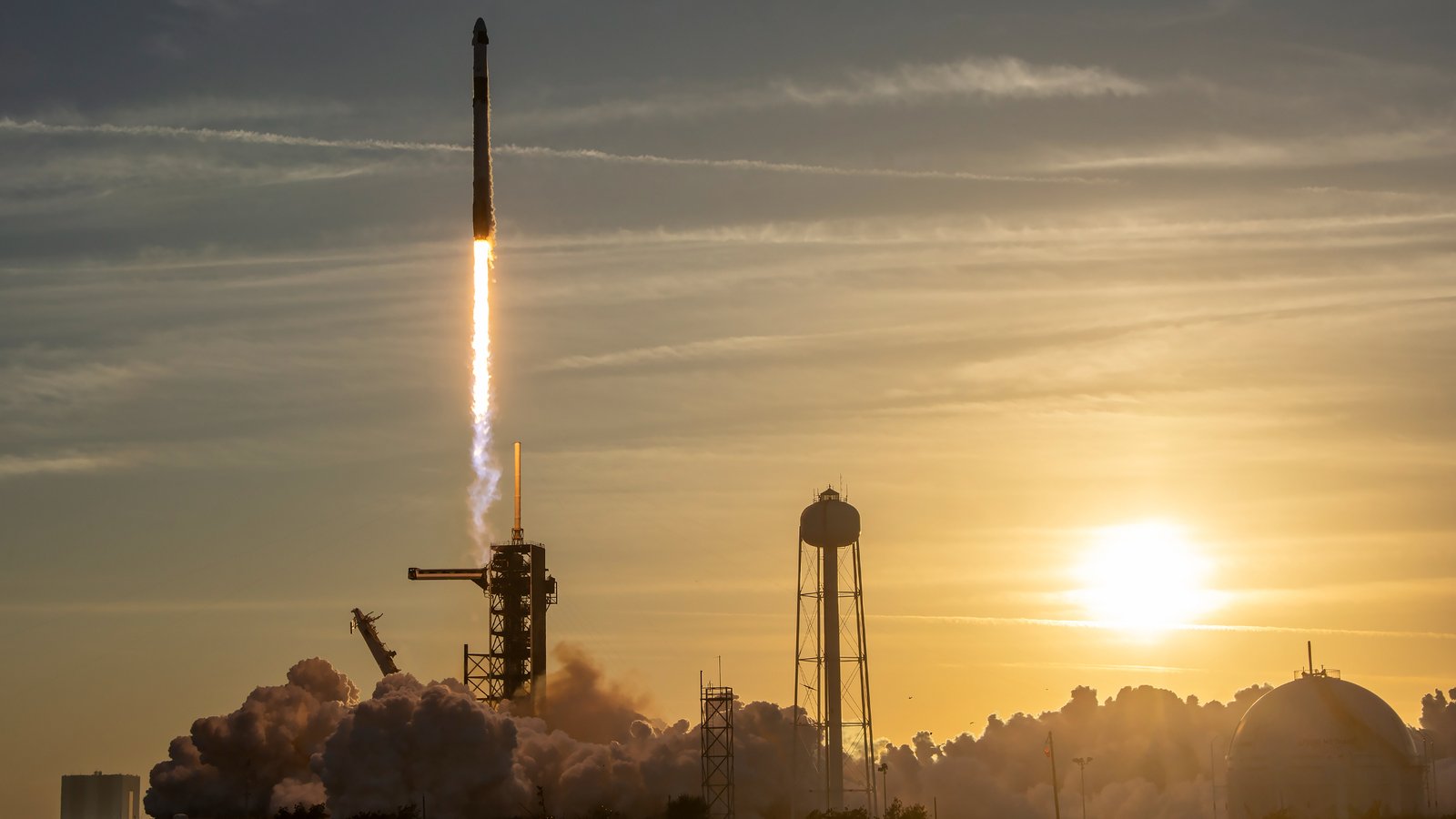 a rocket launches into a sunset sky