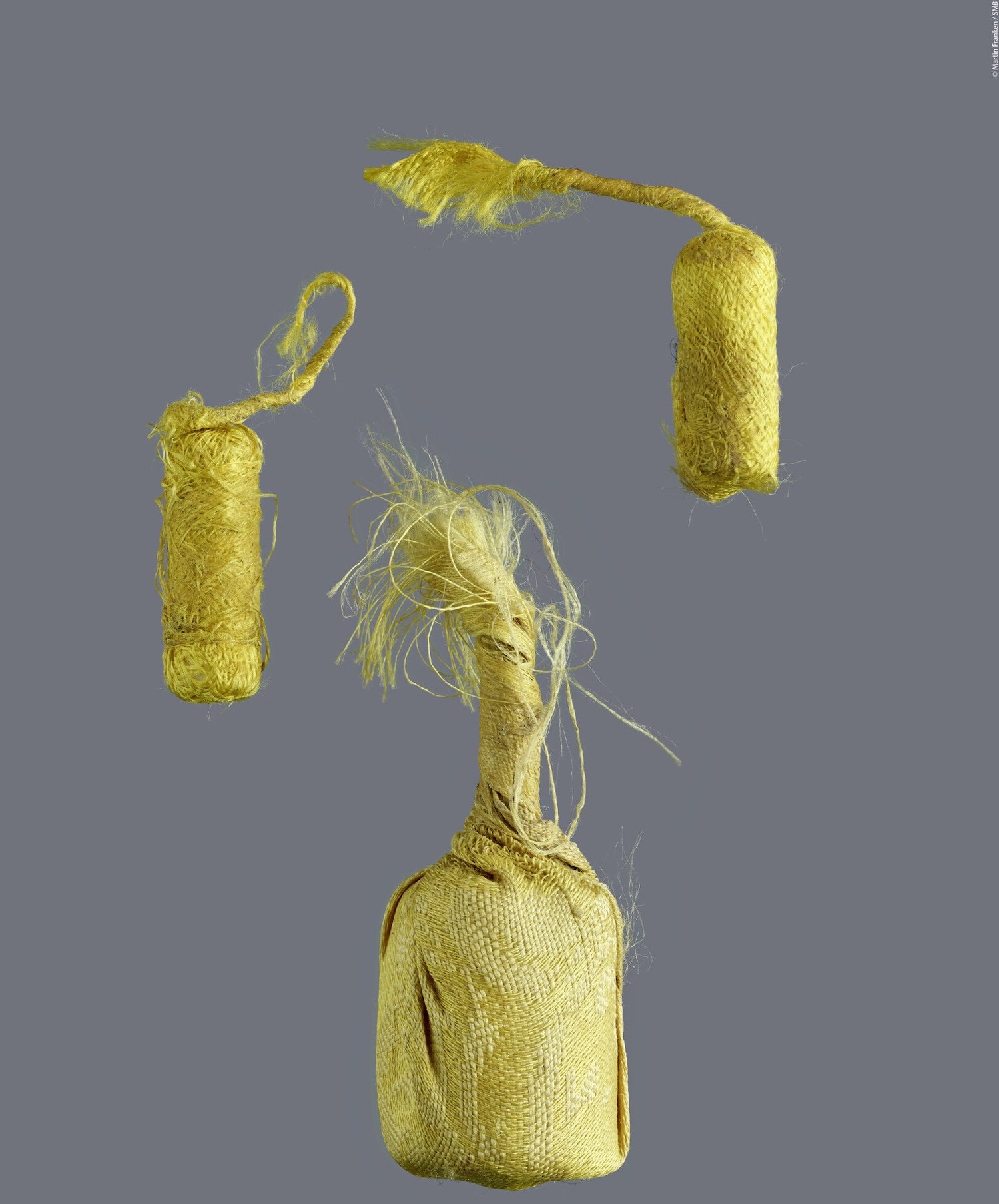 Three Tibetan pray scrolls in yellow silk pouches