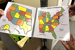 A map for children in braille is held open for a photo at the National Braille Press in Boston.