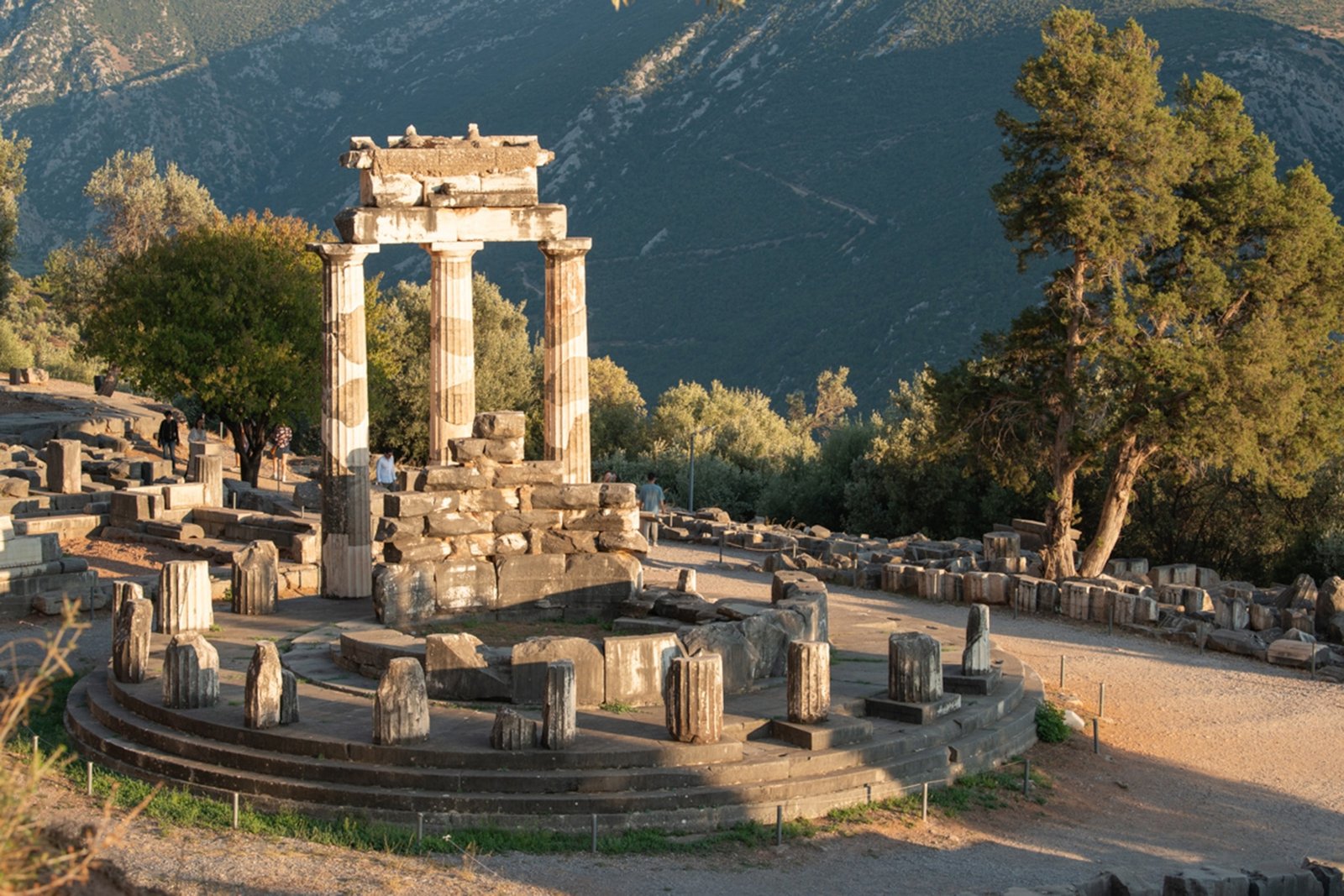 The sunlit ruins of Delphi, pillars protruding from dry hillside.