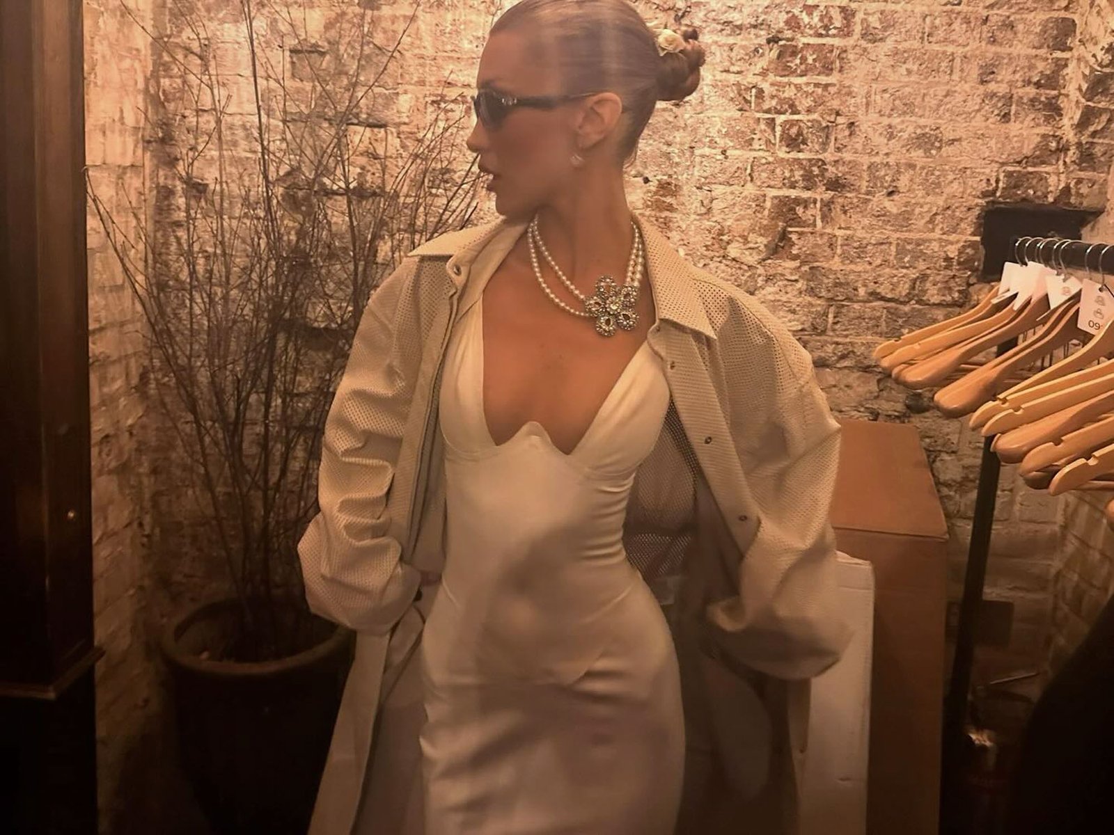 Bella Hadid in a white silk dress and sunglasses. 