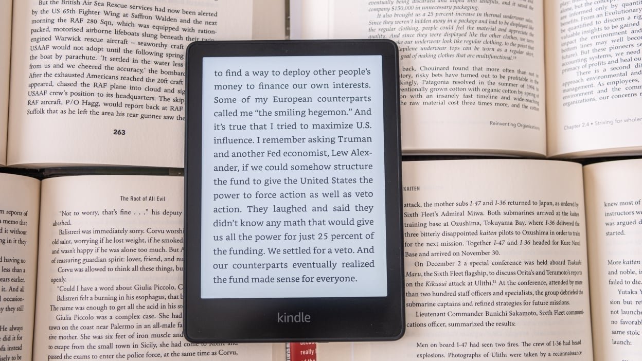 A Kindle pictured over books