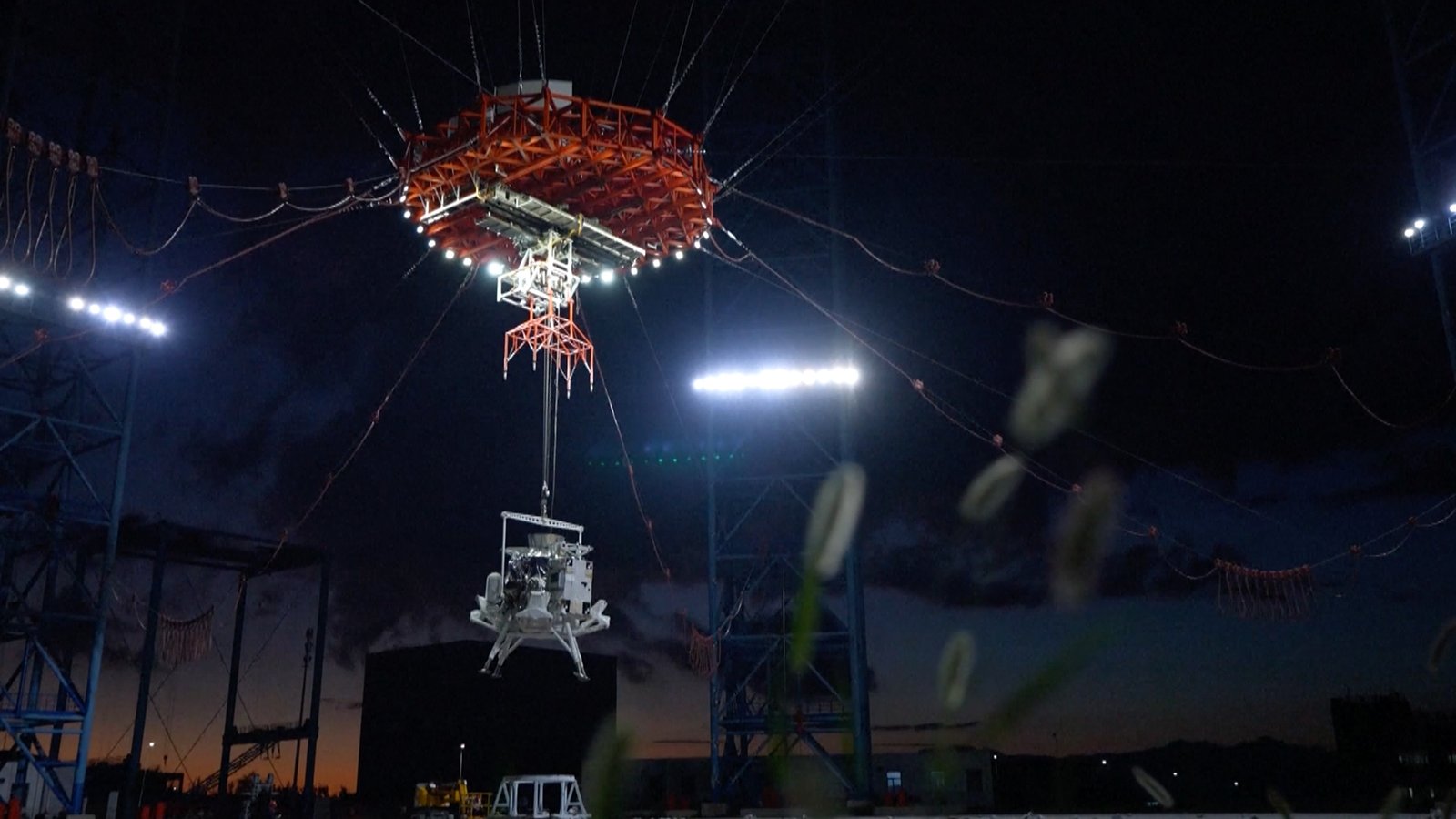China's lunar lander, with four legs, floats down to the surface of Earth via parachute
