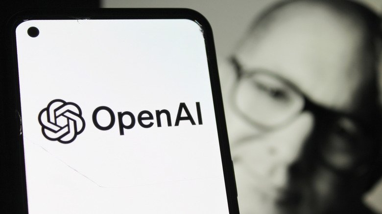 ChatGPT and OpenAI logos on an iPhone with a blurry photo of Jony Ive in the background