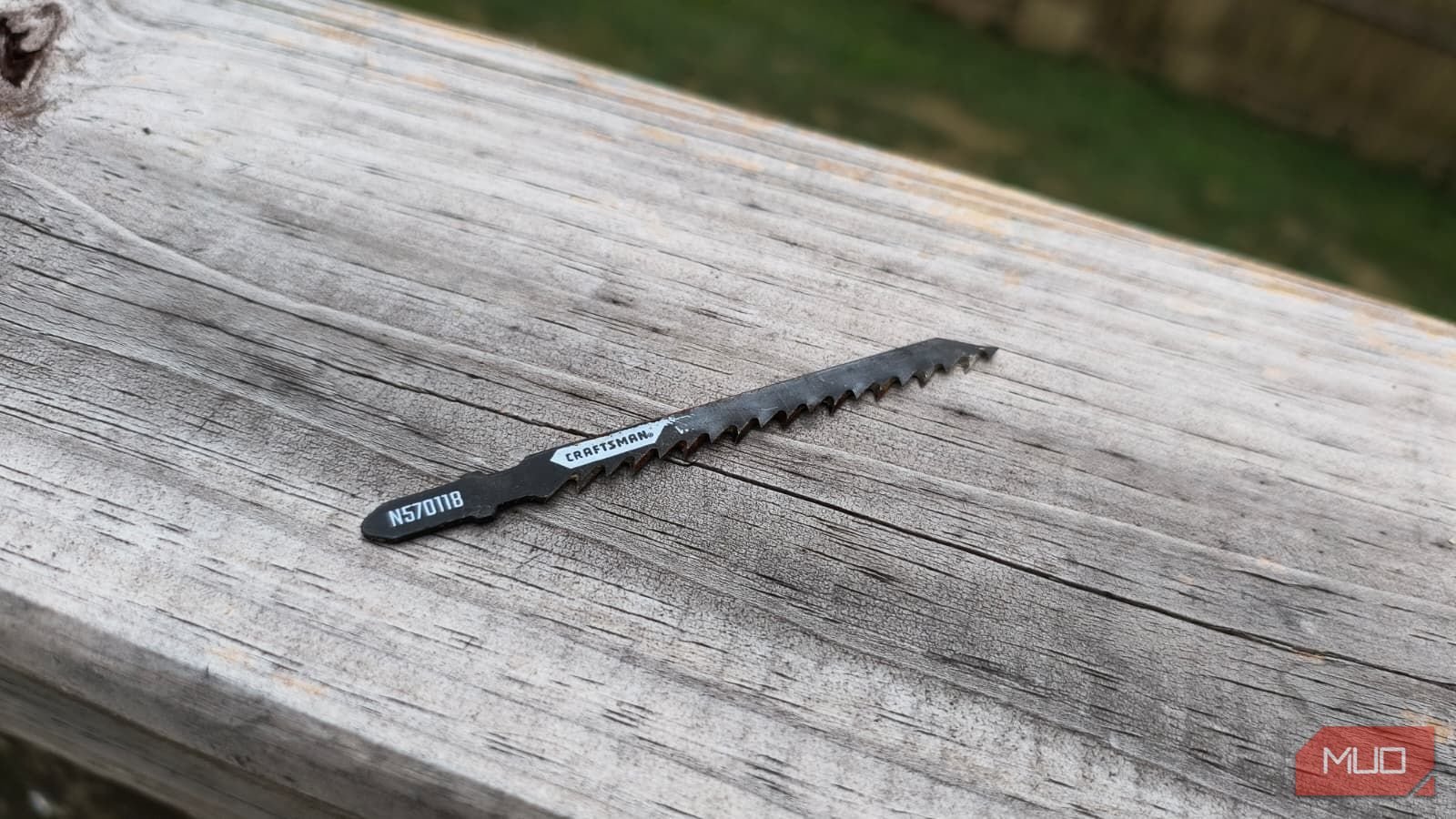 A jigsaw blade sitting on a wooden rail