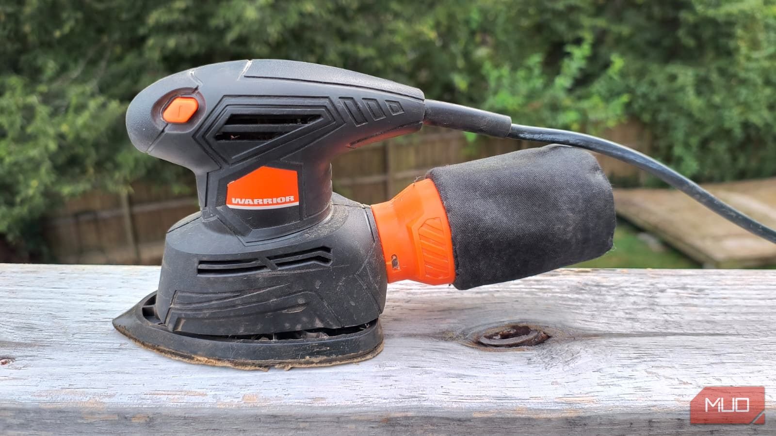 A small electric sander on a wooden rail